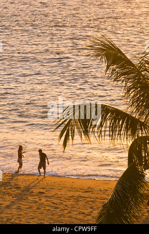 Mexiko, Puerto Vallarta. Mann und Frau Paar am tropischen Strand bei romantischer Sonnenuntergang an der Playa Los Muertos Küste Strand, Puerto Vallarta, Mexiko. Stockfoto