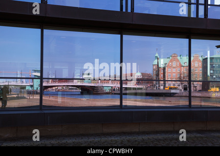 Hafen von Kopenhagen spiegelt sich in einer Glasfassade eines Bürogebäudes. Die Brücke - Knippelsbro- und ein altes Renaissance-Gebäude. Stockfoto