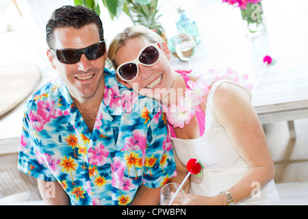 Ein junges Paar lächelnd verkleidet für eine Hawaii-party Stockfoto