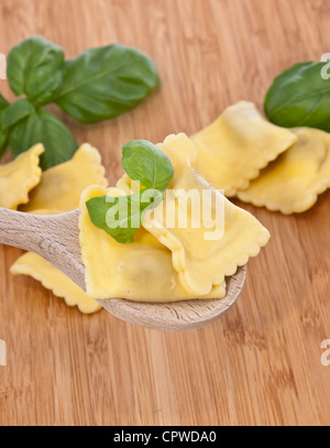 Einige Ravioli dekoriert mit Basilikum auf hölzernen Hintergrund Stockfoto