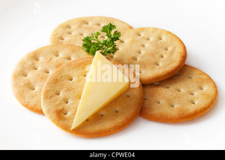 Klassische Snack, Cheddar-Käse und knackig Cracker auf einem weißen Teller garniert mit Petersilie. Clipping-Pfad enthalten. Stockfoto