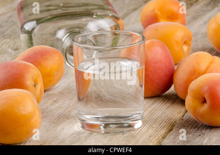 Obstbrände in ein Glas und frischen Aprikosen im Hintergrund Stockfoto