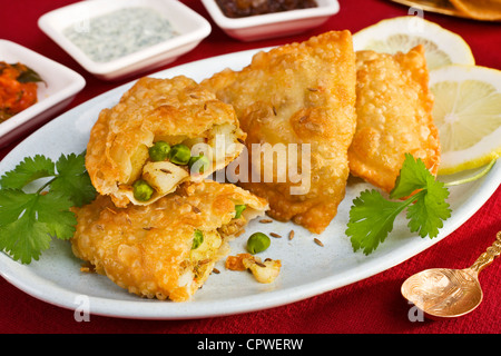 Kartoffeln und Erbsen Samosas mit drei Chutneys. Stockfoto