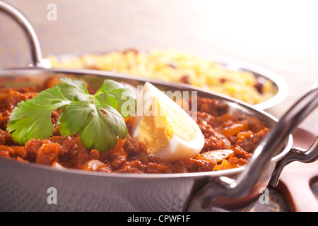 Keema Curry in einem Balti-Teller garniert mit Ei und Koriander. Flachen DOF. Stockfoto