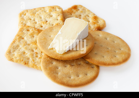 Ein Keil der Camembert Käse auf einem weißen Teller mit Crackern. Stockfoto