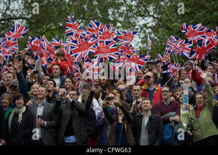 Winken ihren Fahnen, die große britische öffentliche mutig schlechtes Wetter, die Königin Diamond Jubilee Flottille auf der Themse zu feiern. Stockfoto