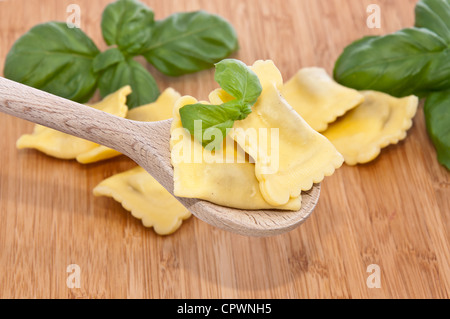 Einige Ravioli dekoriert mit Basilikum auf hölzernen Hintergrund Stockfoto