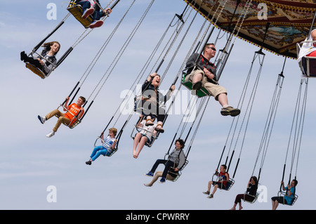 Kinder und Erwachsene genießen eine Fahrt auf "Chairplanes" Kirmes fahren Stockfoto