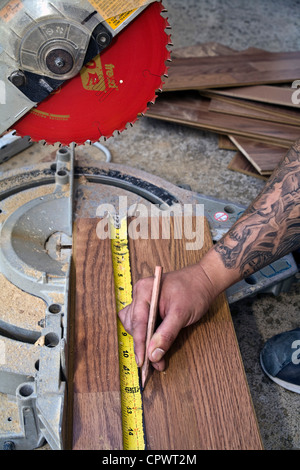 Hispanic Mann mit Tattoos Holz zu messen. Herr © Myrleen Pearson Stockfoto