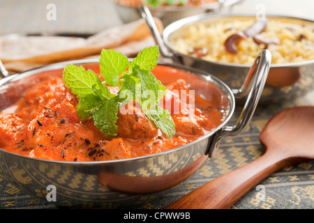 Indisches Essen von Chicken Tikka Masala, garniert mit Minze in Balti Gericht oder Karahi, begleitet von Pilau Reis und Chapati. Stockfoto