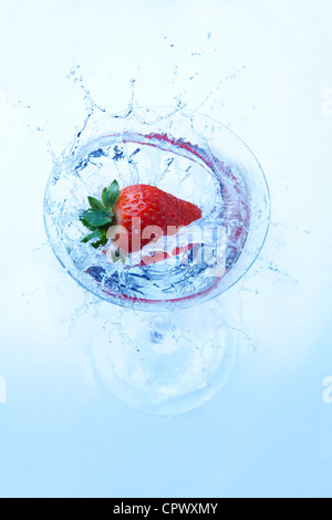 Strawberry Splash in Glas Wasser - frisches Getränk Stockfoto