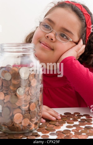 Junges Mädchen mit Krug voller Münzen Stockfoto