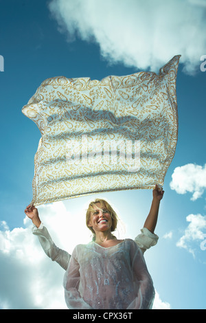 Person, die Sarong in Brise über Frauenkopf Stockfoto