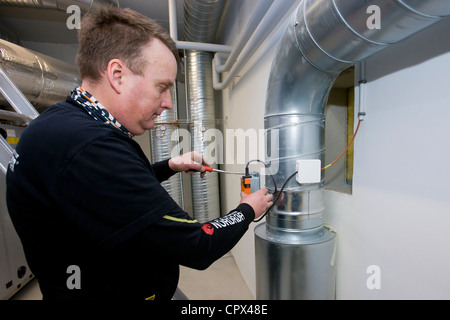 Heizungs- und Sanitär-Techniker installiert einen Temperatursensor Stockfoto