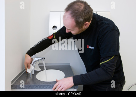 Heizungs- und Sanitär-Techniker Reinigung eine Einhebel-Mischbatterie Stockfoto