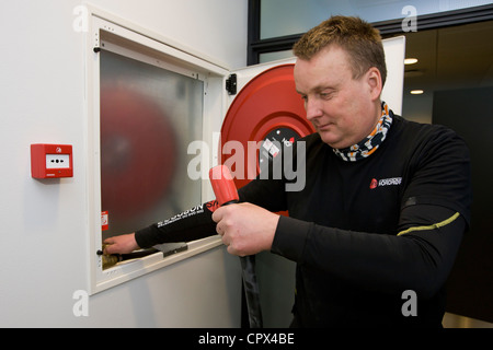 Heizungs- und Sanitär-Techniker testen einen Feuerwehrschlauch Stockfoto