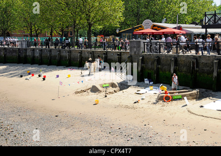 Kleiner Bereich der Ebbe Sandstrand neben Themse eingesetzt von Männern, die Schaffung von Sand Skulpturen in der Hoffnung auf Spenden von Besuchern Stockfoto