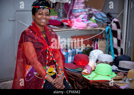 Straßenhändler, gekleidet in traditioneller Kleidung lächelt in die Kamera Stockfoto