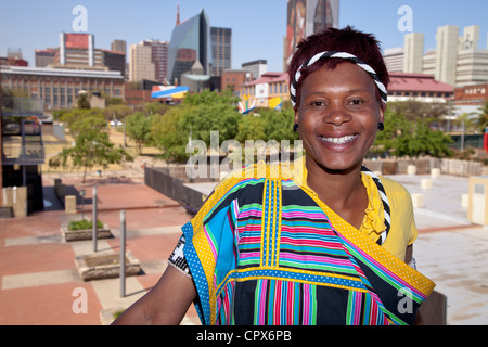 Afrikanische Frau, gekleidet in traditioneller Kleidung lächelt in die Kamera Stockfoto