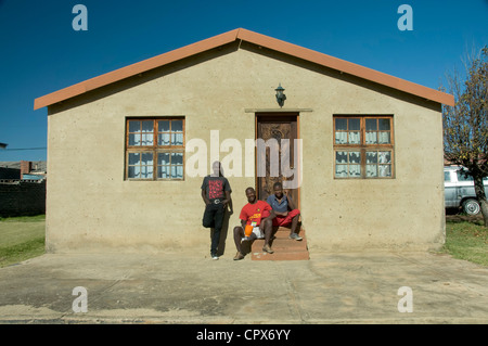 Veranda eines Hauses mit drei schwarze Männer sitzen auf der Stufe Stockfoto