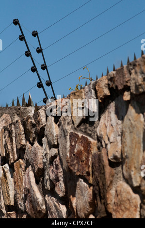 Nahaufnahme einer Facebrick Wand mit Elektrozaun Stockfoto