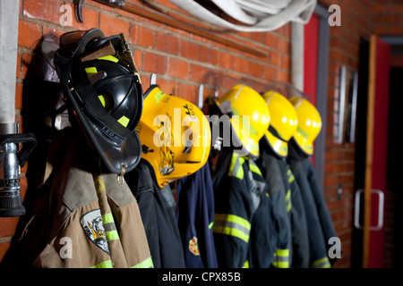 Feuerwehr-Uniformen, die an einer Wand aufhängen Stockfoto