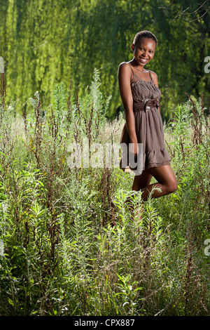 Junge Erwachsene funky schwarze weibliche draußen lächelnd in die Kamera Stockfoto
