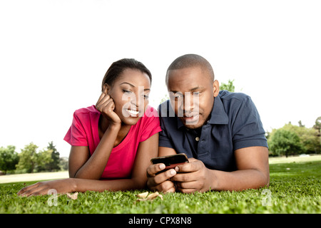 Closeup Portrait eines jungen Paares schwarz, auf dem Boden liegen, während Man mit dem Handy spielt Stockfoto