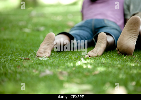 Schuss von hinten von einem jungen schwarzen paar liegen auf dem Rasen in einem Park Stockfoto