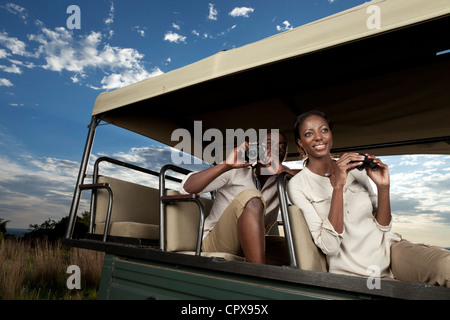 Eine afrikanische paar sitzt in einem Spiel zu betrachten-Fahrzeug auf der Suche nach Tieren Stockfoto
