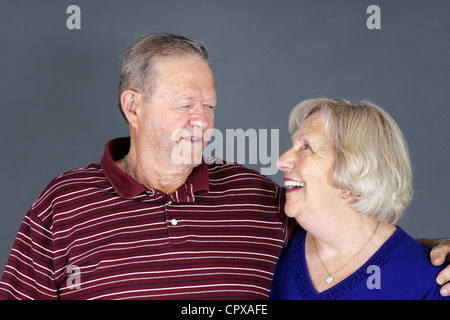 Gerne älteres Paar, gemeinsam lachen, Studio über grauen Hintergrund erschossen. Stockfoto