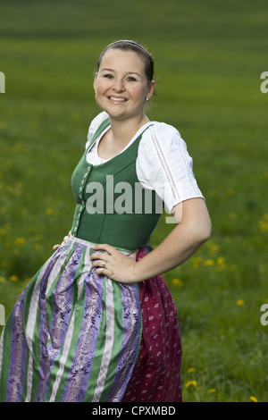 Junge Frau mit österreichischen traditionelle Kleidung auf einer grünen Wiese Stockfoto