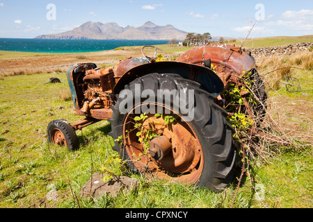 Eine alte Traktor verlassen bei der Cleadale auf der Insel Eigg, mit Blick auf die Isle of Rum, Schottland, UK. Stockfoto