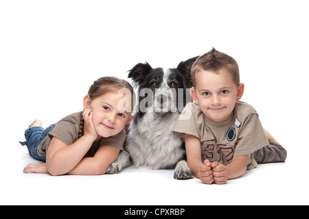 Zwei Kinder und ein Border-Collie-Schäferhund vor einem weißen Hintergrund Stockfoto