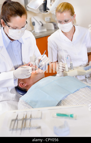 Zahnärztin und Krankenschwester Betrieb auf männliche Patienten zu tun Stockfoto