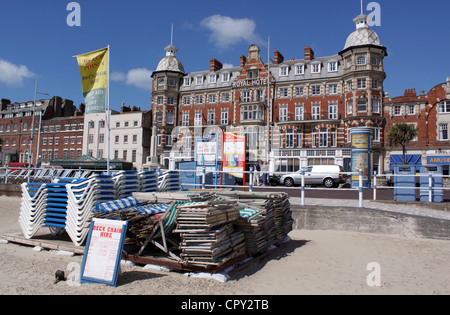 LIEGESTÜHLE GESTAPELT AM WEYMOUTH BEACH DORSET Stockfoto