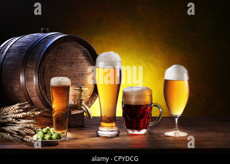 Bierfass mit Biergläsern auf einem Holztisch. Der dunkle Hintergrund. Stockfoto