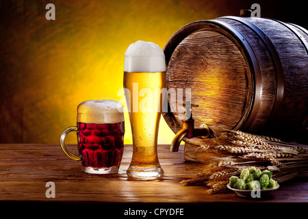 Bierfass mit Biergläsern auf einem Holztisch. Der dunkle Hintergrund. Stockfoto