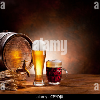 Bierfass mit Biergläsern auf einem Holztisch. Der dunkle Hintergrund. Stockfoto