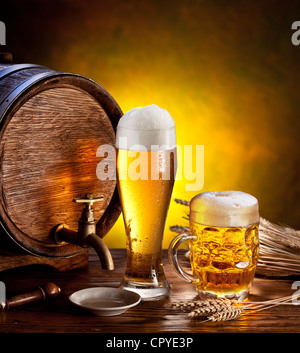 Bierfass mit Biergläsern auf einem Holztisch. Der dunkle Hintergrund. Stockfoto