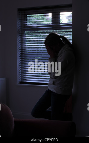 Profil von einem Mädchen mit einem Pferdeschwanz, stehend Händen bedeckte ihr Gesicht. Silhouette. Stockfoto