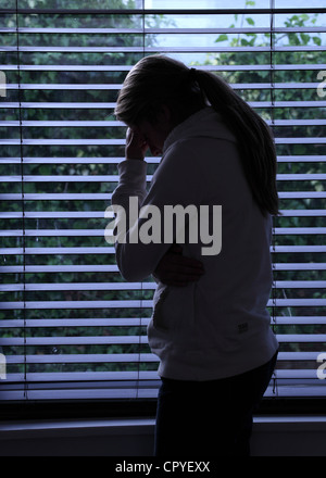 Profil von einem Mädchen mit einem Pferdeschwanz, stehend Händen bedeckte ihr Gesicht. Silhouette. Stockfoto