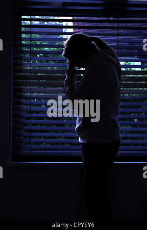 Profil von einem Mädchen mit einem Pferdeschwanz, stehend Händen bedeckte ihr Gesicht. Silhouette. Stockfoto