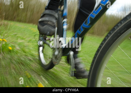 Mountainbiken mit Geschwindigkeit entlang einer schlammigen Langlauf-Route zeigt Detail Rad Fahrer Klemmen Pedale aus einem niedrigen Winkel Stockfoto