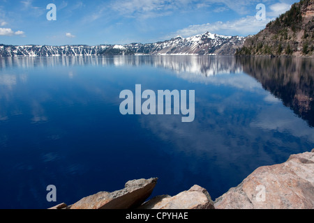 Einen malerischen Blick auf den Kratersee, Oregon, USA (7. tiefste See der Welt) mit Cloud Reflexionen auf dem See. Aufgenommen im Juni. Stockfoto