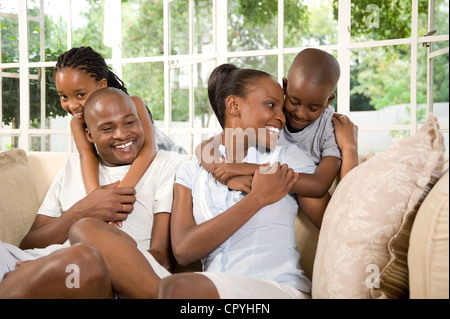 Junge afrikanische verheiratet paar spielen mit ihren beiden Kindern auf einer couch Stockfoto