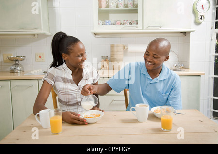 Junge afrikanische Ehepaar frühstücken zusammen an einem Küchentisch Stockfoto