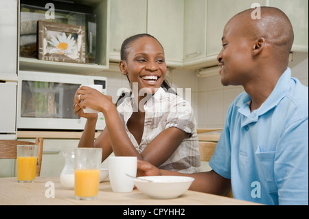 Junge afrikanische Ehepaar frühstücken zusammen an einem Küchentisch Stockfoto