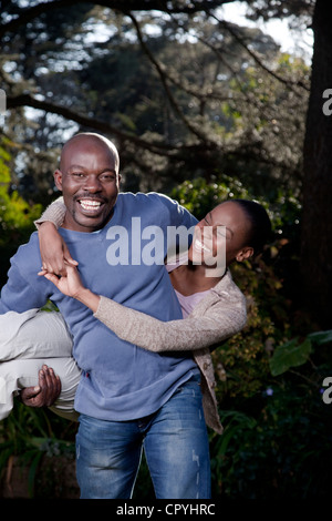 Ein Mann trägt spielerisch seine Frau, Illovo Familie, Johannesburg, Südafrika. Stockfoto