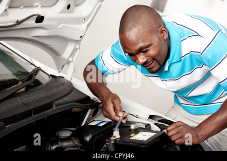 Afrikanischer Mann arbeitet an einem Automotor Stockfoto